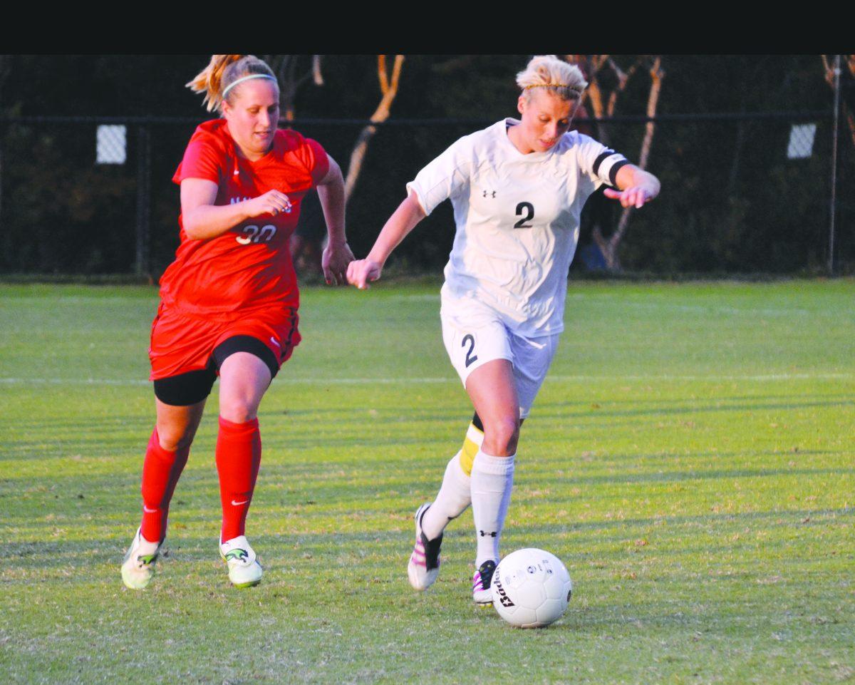 Stacie Murenzo dribbling the ball up the pitch against Navarro College. 
