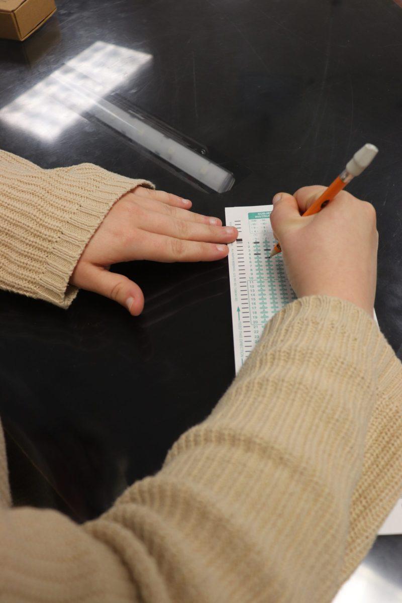 an over the shoulder shot of someone filling in a scantron