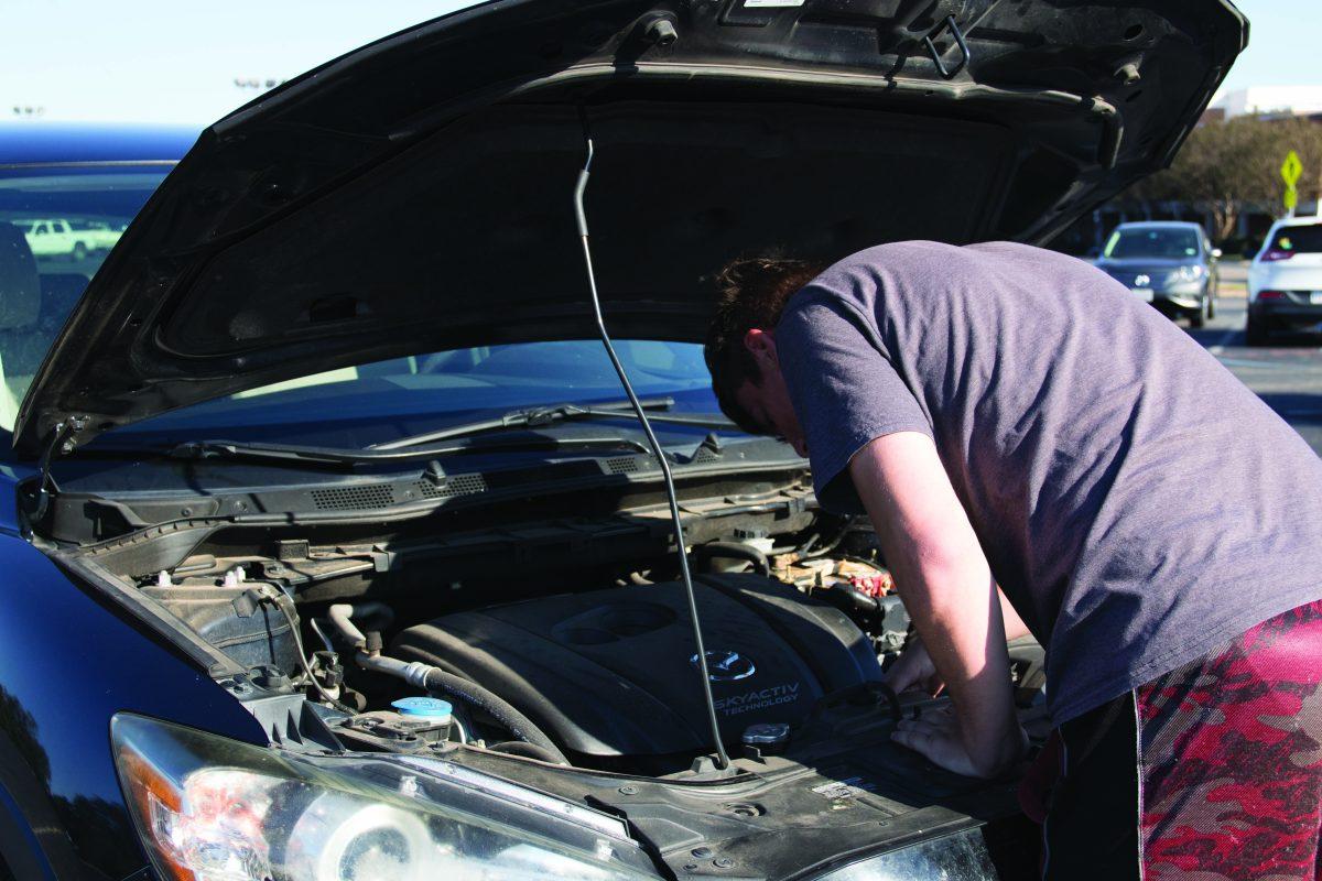 a man working under the hood of a car