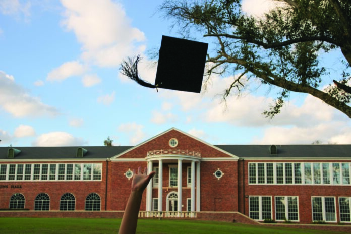 The front of a college building with someone throwing a graduation cap in the air