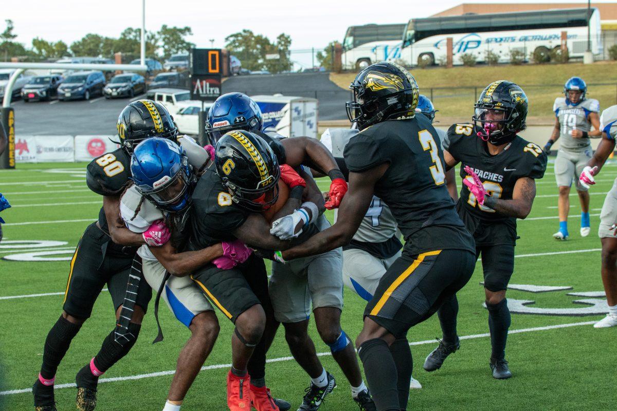 No. 6, a TJC Apache, and their teammates tangle with the Cisco College Wranglers. The teammates are assisting in trying to push No. 6 further.