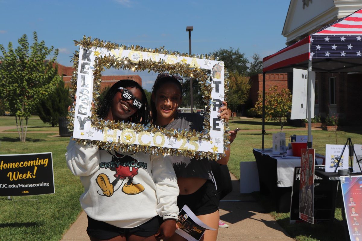 Samantha Houston (Nursing) and her cheer friend pose outside of the Turning Point USA table for homecoming.  