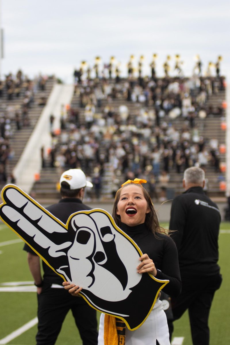 Photo by Ian Frye. Cheer member Laney Kolden rousing the Apache fans. Apache cheer will be celebrating 100 years of cheering in 2026. Photo taken on November 1, 2025.