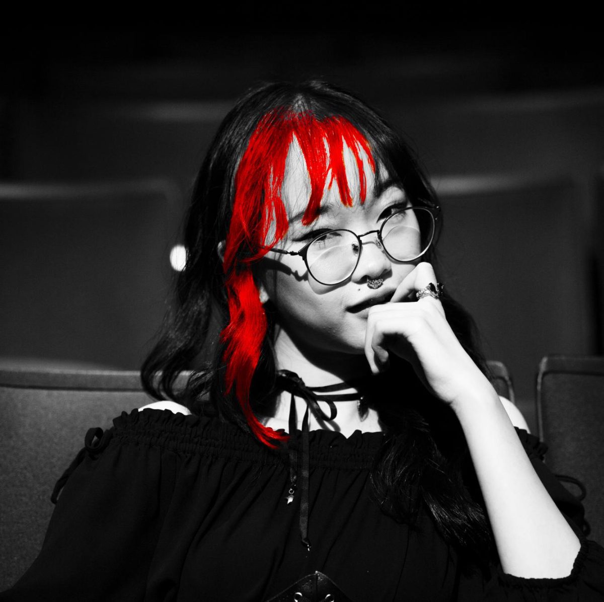 Las Mascaras President, Kay Do, poses for the camera, highlighting the red streaks in her hair. Sitting in the Jean Brown Theatre, Do glared at the camera with a sense of strength, courage, and purpose. Photo taken and Edited by Imogen Brown 